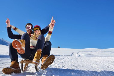 Kızak ve güneşli kış gününde zevk genç Çift