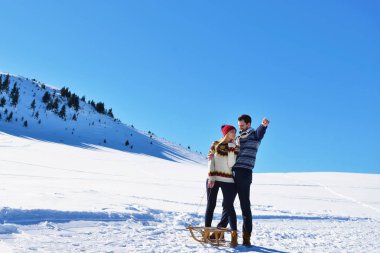 Kızak ve güneşli kış gününde zevk genç Çift