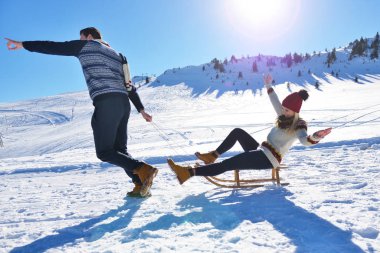 Kızak ve güneşli kış gününde zevk genç Çift