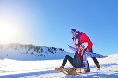 Kızak ve güneşli kış gününde zevk genç Çift