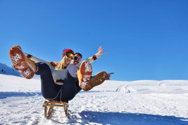 Kızak ve güneşli kış gününde zevk genç Çift