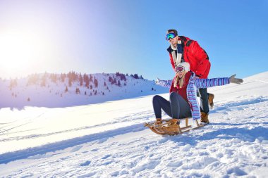 Kızak ve güneşli kış gününde zevk genç Çift