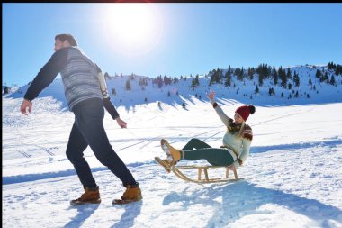 Kızak ve güneşli kış gününde zevk genç Çift