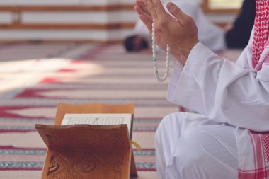 Dindar Müslüman adam caminin içinde dua ediyor.