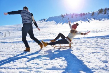 Kızak ve güneşli kış gününde zevk genç Çift