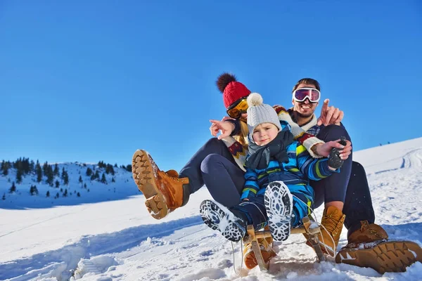 Feliz familia joven jugando en nieve fresca en hermoso día de invierno soleado al aire libre en la naturaleza —  Fotos de Stock