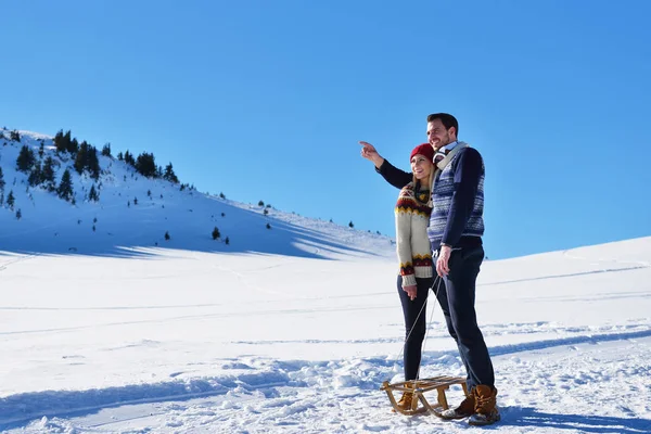 Kızak ve güneşli kış gününde zevk genç Çift