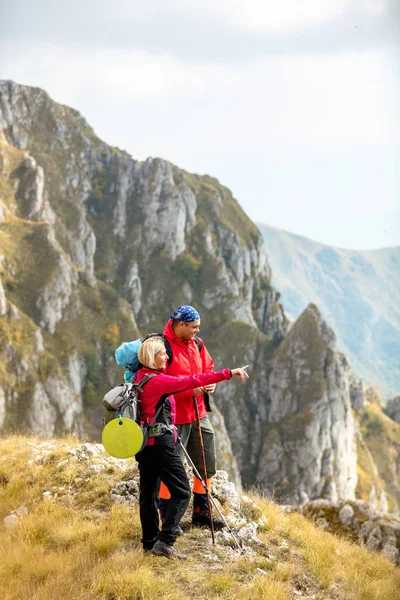 Adventure, travel, tourism, hike and people concept - smiling couple walking with backpacks outdoors — Stock Photo, Image