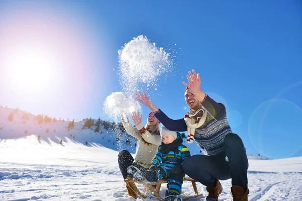 Feliz familia joven jugando en nieve fresca en hermoso día de invierno soleado al aire libre en la naturaleza —  Fotos de Stock