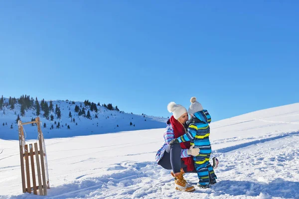 happy young family playing in fresh snow at beautiful sunny winter day outdoor in nature