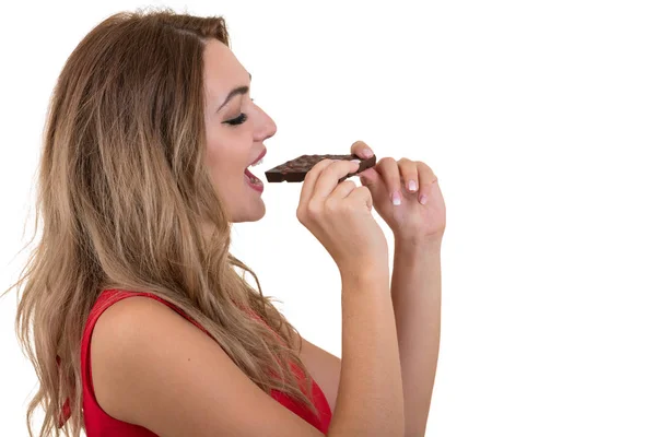 Молода і красива жінка їсть смачний темний шоколад — стокове фото