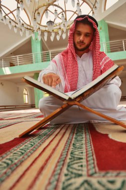 Dindar Müslüman adam caminin içinde dua ediyor.