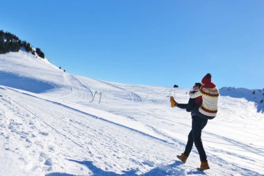Genç çift kar üzerinde eğleniyor. Sırtıma binmek gülümseyen kız arkadaşına veren Mountain mutlu adam.