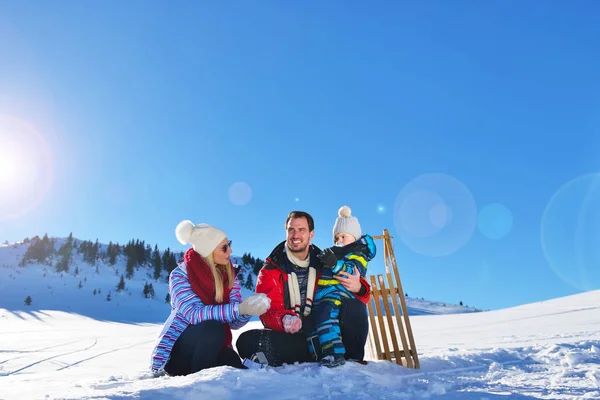 幸福年轻的家庭，在新鲜的雪打美丽晴朗的冬日户外性质 — 图库照片