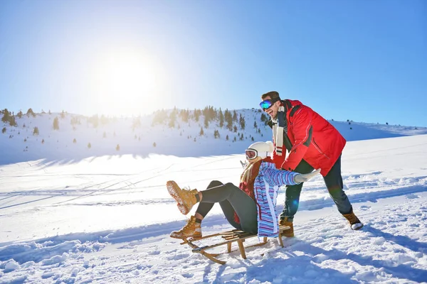 Junges Paar rodelt und genießt an sonnigem Wintertag — Stockfoto