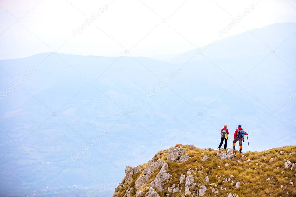 adventure, travel, tourism, hike and people concept - smiling couple walking with backpacks outdoors