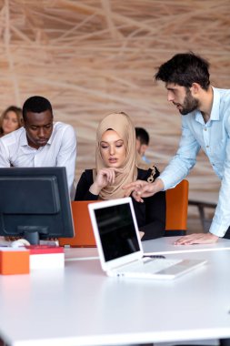 Girişim ekibi, modern parlak ofis içi beyin fırtınası, dizüstü bilgisayar ve tablet bilgisayar üzerine toplantı üzerine çalışıyor