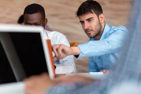 Dos hombres de negocios inteligentes utilizando el teléfono inteligente y portátil workig en la oficina . — Foto de Stock