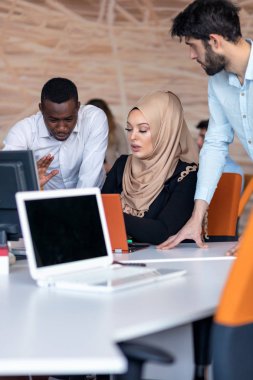 Girişim ekibi, modern parlak ofis içi beyin fırtınası, dizüstü bilgisayar ve tablet bilgisayar üzerine toplantı üzerine çalışıyor