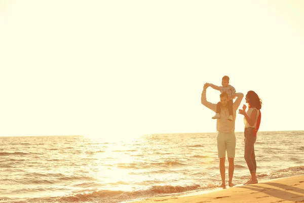 Retrato de familia feliz y bebé disfrutando de la puesta de sol en el ocio de verano — Foto de Stock