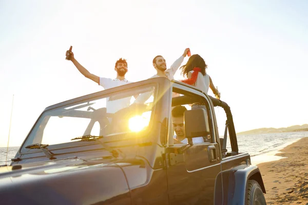 Gruppe fröhlicher Freunde feiert Party im Auto - junge Leute haben Spaß beim Champagnertrinken — Stockfoto