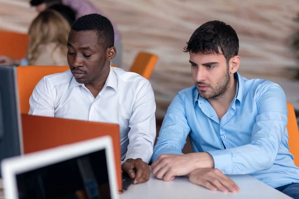 Deux hommes d'affaires intelligents utilisant smartphone et ordinateur portable workig dans le bureau . — Photo