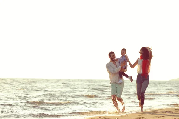 Retrato de familia feliz y bebé disfrutando de la puesta de sol en el ocio de verano — Foto de Stock