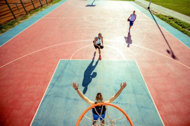 Basketbolcunun basketbolu potada smaç basmasının yüksek açılı görüntüsü