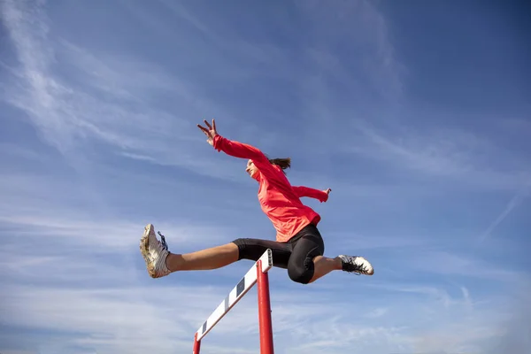 Atleta saltando por encima del obstáculo durante la carrera — Foto de Stock