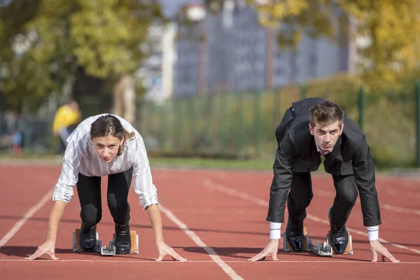 Close up of 20 year old businessmen and businesswoman ready to run at start point. — Stock Photo, Image