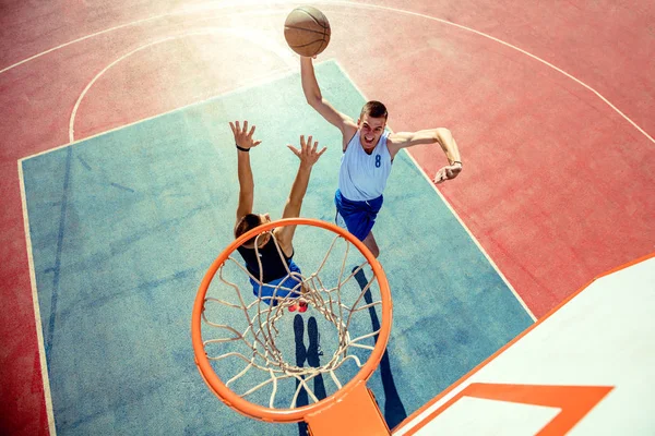 Баскетболист с высоким углом обзора бросает мяч в кольцо — стоковое фото
