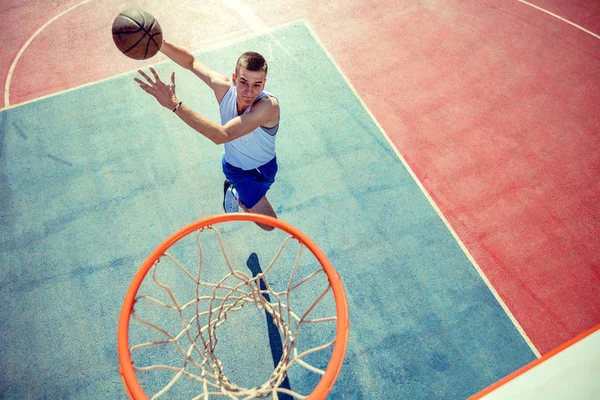 Vista de alto ângulo do jogador de basquete mascando basquete em aro — Fotografia de Stock