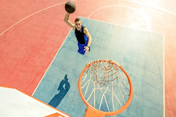 Vista de alto ângulo do jogador de basquete mascando basquete em aro — Fotografia de Stock