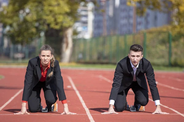 Close up of 20 year old businessmen and businesswoman ready to run at start point. — Stock Photo, Image