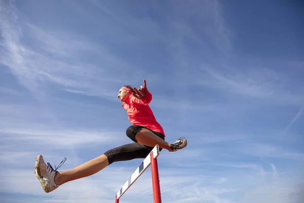 Atleta saltando por encima del obstáculo durante la carrera — Foto de Stock