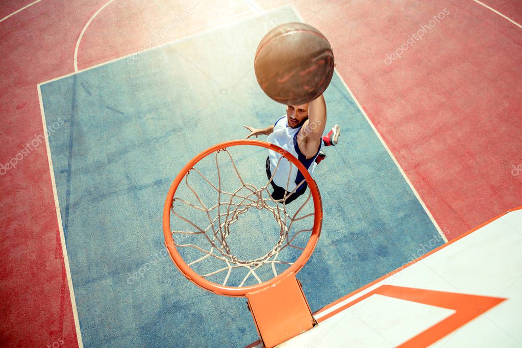 High angle view of basketball player dunking basketball in hoop