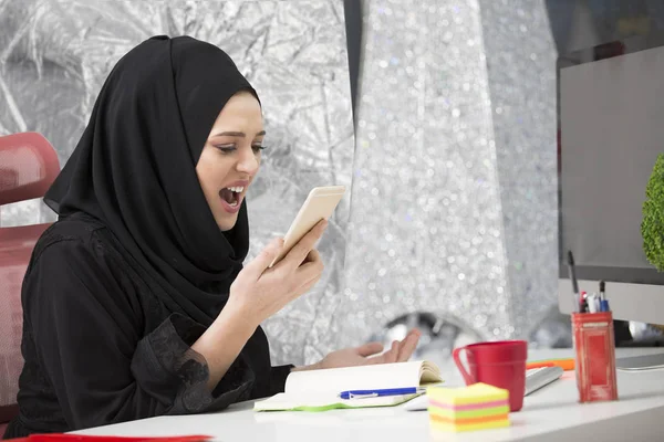 Muslim perempuan pekerja berbicara di telepon saat bekerja dengan komputer laptop — Stok Foto