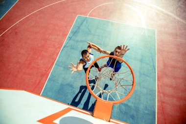 Basketbolcunun basketbolu potada smaç basmasının yüksek açılı görüntüsü