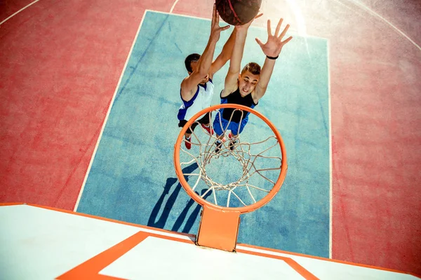 Vista de alto ângulo do jogador de basquete mascando basquete em aro — Fotografia de Stock