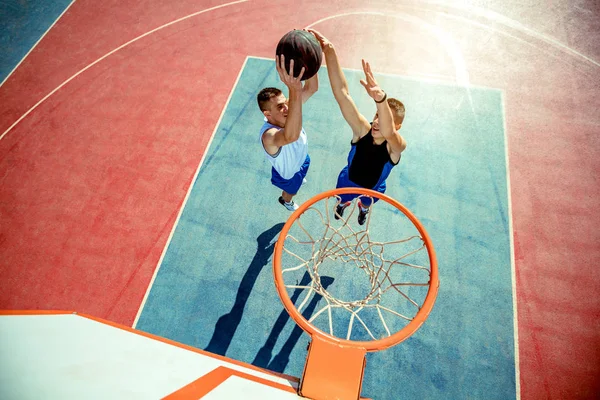 Vista de alto ângulo do jogador de basquete mascando basquete em aro — Fotografia de Stock