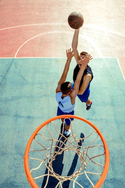 Vista de alto ângulo do jogador de basquete mascando basquete em aro — Fotografia de Stock