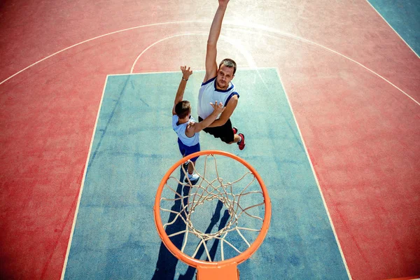 Vista de ángulo alto del jugador de baloncesto que zambulle en el aro — Foto de Stock