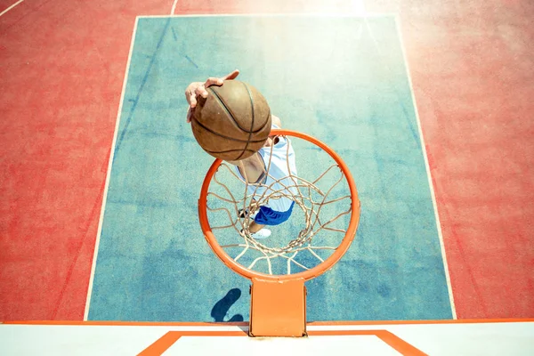 Jongeman die springt en een fantastische slam dunk maakt door streetball te spelen, basketbal. Stedelijk authentiek. — Stockfoto