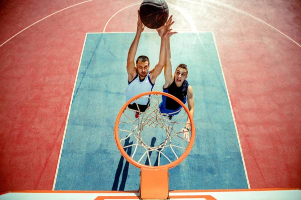 バスケットボール選手ダンクバスケットボールの高い角度ビューでフープ — ストック写真