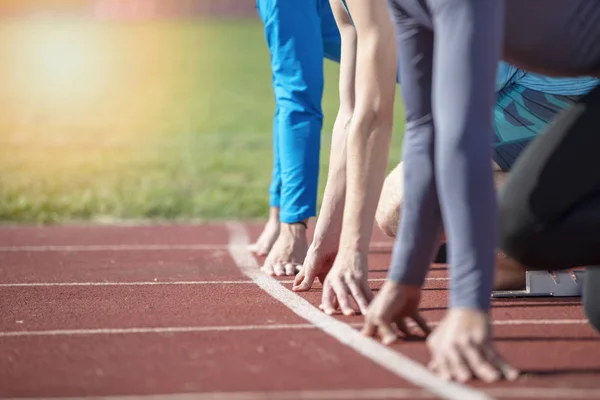 Atletas na linha de partida do sprint em pista e campo — Fotografia de Stock