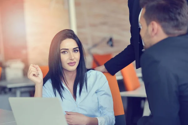 Imagen de la mujer usando el portátil mientras está sentada en su escritorio . — Foto de Stock