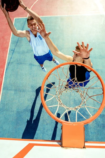 Vista de alto ângulo do jogador de basquete mascando basquete em aro — Fotografia de Stock