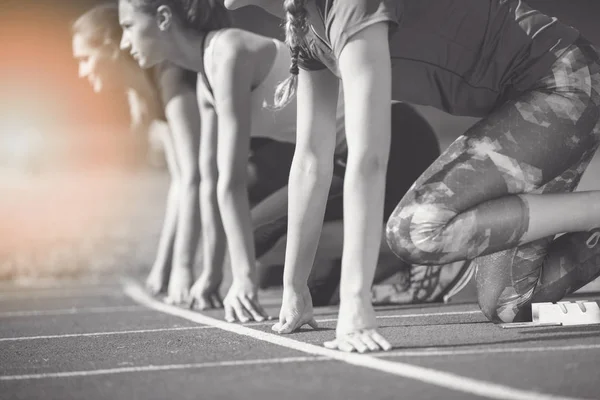Женщины готовы к гонке на легкоатлетическом поле — стоковое фото