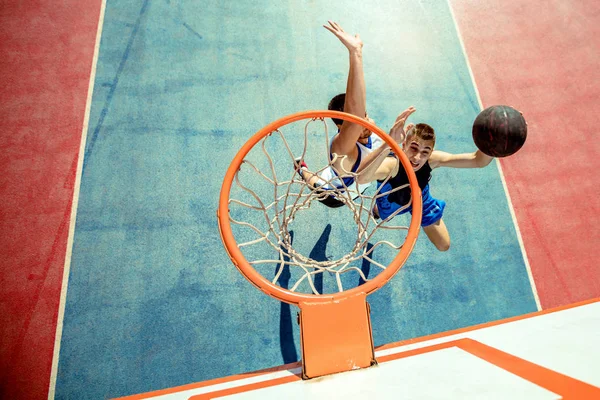 Vista de alto ângulo do jogador de basquete mascando basquete em aro — Fotografia de Stock