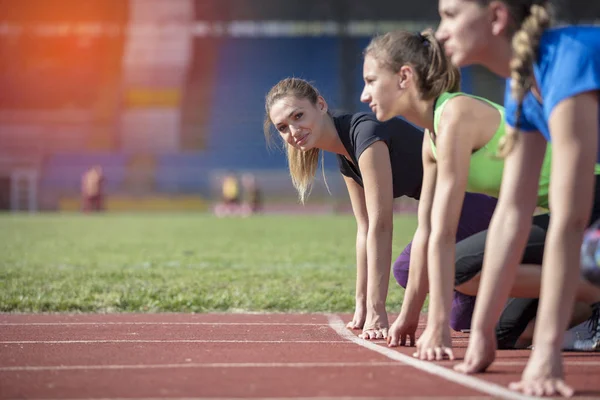 Women ready to race on track field — Stock Photo, Image